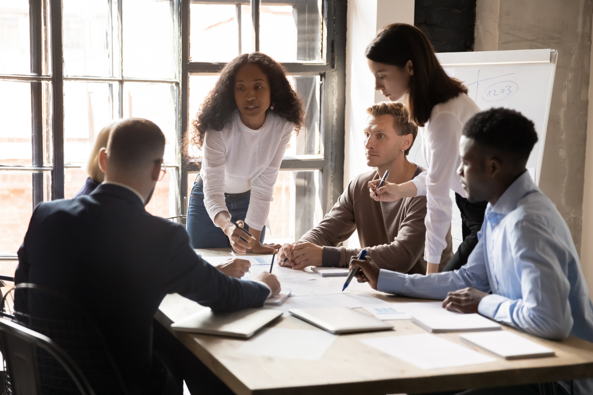 Serious diverse business team and african leader discuss financial paperwork